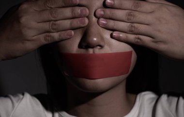 Kadın gözlerini kapatır ve ağzını yapıştırıcı bant ile kapatır. Konuşma özgürlüğü, sansür, basın özgürlüğü ve Uluslararası İnsan Hakları Günü kavramını.