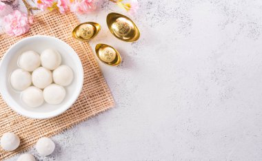 Tang Yuan (tatlı köfteler), Sonbaharın ortası, Dongzhi (kış gündönümü) ve Çin yeni yılı için geleneksel bir yemektir. Çince karakterler FU makalede servet, servet, para akışına atıfta bulunur.
