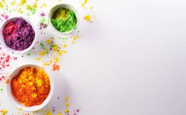 Mutlu Holi dekorasyonu, Hint festivali. Beyaz arka planda renkli holi tozunun üst görüntüsü..