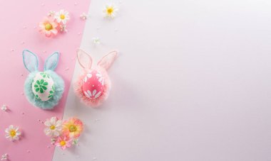 Paskalya dekorasyonun kutlu olsun. Renkli Paskalya yumurtaları pembe ve beyaz arka planda çiçekler.