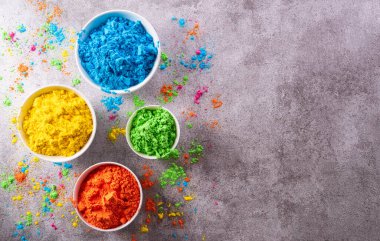 Mutlu Holi dekorasyonu, Hint festivali. Koyu taştan arka planda renkli holi tozu manzarası..