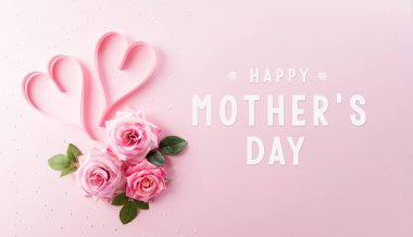 Gül çiçeği ve kalpten yapılmış pembe pastel arka planda yazılı Mutlu Kadınlar Günü dekorasyonu konsepti.