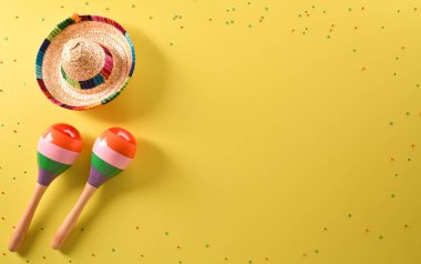 Cinco de Mayo tatil geçmişi marakas ve sarı arka planda şapka.
