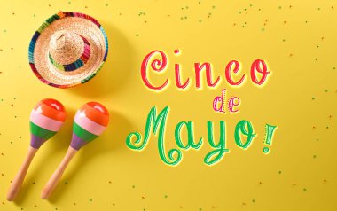 Cinco de Mayo tatil arka planı marakas, şapka ve sarı arkaplandaki metinden yapılmıştır..