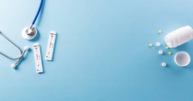 Covid-19 hızlı antijen testi, steteskop ve mavi arka planda ilaç. Dünya çapında koronavirüs salgını konsepti.