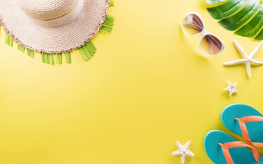 Yaz kompozisyonu konsepti deniz yıldızı, plaj şapkası, parmak arası terlik ve pastel sarısı arka planda canavar yaprağı..