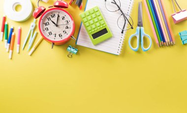 Eğitim ya da okula dönüş konsepti. Renkli okul malzemelerinin kitaplarla, renkli kalemlerle, hesap makinesiyle, ataçlarla ve pastel kağıt üzerinde elmayla en iyi görünümü.