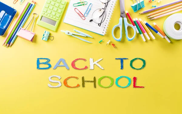 Eğitim ya da okula dönüş konsepti. Renkli okul malzemelerinin kitaplarla, renkli kalemlerle, hesap makinesiyle, ataçlarla ve pastel kağıt üzerinde elmayla en iyi görünümü.