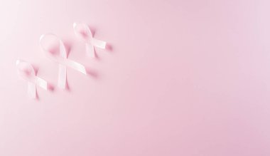 Pastel arka planda pembe kurdeleler, kadınların meme kanseri farkındalığı, sağlık ve tıbbi konseptin sembolü..
