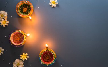Happy Diwali - Clay Diya lamps lit during Diwali, Hindu festival of lights celebration. Colorful traditional oil lamp diya on blue background