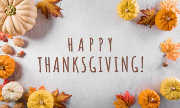 Şükran Günü ve sonbahar dekorasyon konsepti. Balkabağı, sonbahar yaprakları ve arkaplanda taş arkaplan yazılı elma..