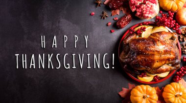 Şükran Günü yemeği arka planı kavrulmuş hindi ve tüm yan yemekleri, güz yaprakları, balkabağı ve koyu taş arka planda mevsimsel sonbahar dekoru, üst manzara, fotokopi alanı.