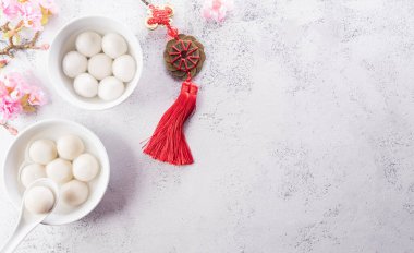 Tang Yuan (tatlı köfteler), Sonbaharın ortası, Dongzhi (kış gündönümü) ve Çin yeni yılı için geleneksel bir yemektir. Çince karakterler FU makalede servet, servet, para akışına atıfta bulunur.