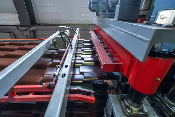Línea de producción de baldosas metálicas para techo. Máquina formadora de acero en taller de fábrica de metalurgia. Máquina de perfilado de chapa — Foto de Stock
