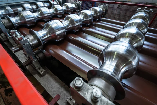 Rodillos de acero en la máquina formadora de metales para la producción de tejas en fábrica — Foto de Stock