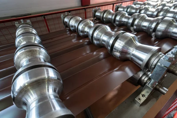 Línea de producción de baldosas metálicas para techo. Máquina formadora de acero en taller de fábrica de metalurgia. Máquina de perfilado de chapa — Foto de Stock
