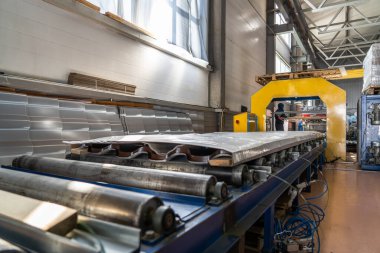 Metal fabrikasının atölyesinde çatı için metal döşeme levhalarının bitmiş paketlenmiş ürünlerini taşıyan taşıyıcı