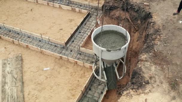 İnşaat sahasında çalışanlar beton dökerken takviyeyle birlikte. Sivil yapı temeline, hava manzarasına ıslak çimento dökülüyor — Stok video