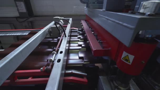 Galvanizli ve boyalı çelikten yapılmış kahverengi metal kiremitler metal fabrikasında metal levha oluşturma makinesinde — Stok video