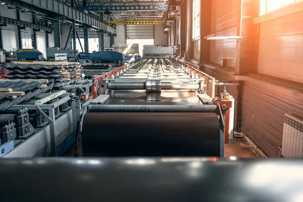 Taller de fábrica industrial o interior de almacén para la producción de tejas metálicas. Producción de techos en cintas transportadoras automatizadas y equipos de líneas — Foto de Stock