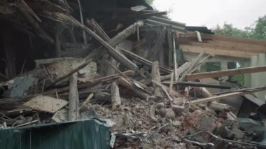 Yıkılmış ev, ahşap ve taş atıkları, yıkılmış ev ve kazıcı kovası kalıntıları.