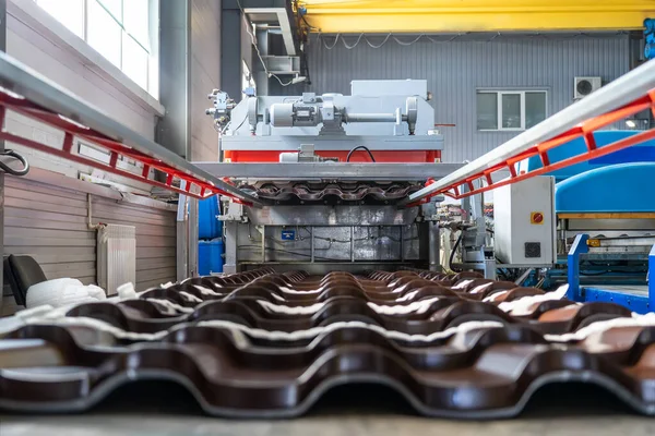 Ubin atap logam terbuat dari baja galvanis dalam lembaran logam membentuk mesin di pabrik logam — Stok Foto