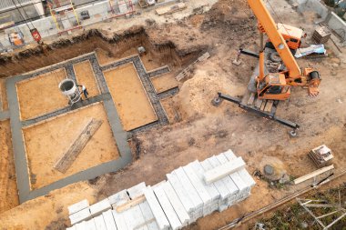 Gelecekteki evin temeli. İnşaat alanına vinç ve hava manzaralı çimento dökerek.