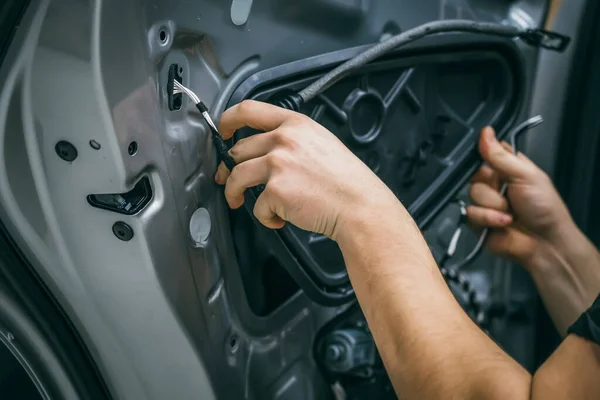 Pekerja jasa otomotif menutup pintu mobil untuk perbaikan, restorasi, penyetelan suara mobil atau memasang insulasi kebisingan atau kedap suara — Stok Foto