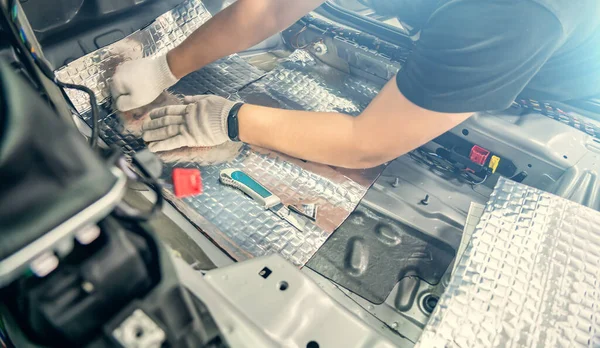 Pekerja layanan otomotif memasang bahan kedap suara di dalam interior mobil, insulasi kedap suara — Stok Foto