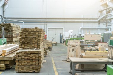 Büyük marangoz fabrikası atölyesinde. İçi ahşap yığınlarıyla dolu.