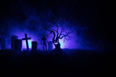 Zombilerin mezarlıktaki ölü ağaç, ay, kilise ve sisli ürkütücü bulutlu gökyüzü, Korku Cadılar Bayramı konsepti. Seçici odak