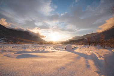 Kış dağlarının manzarasında muhteşem bir günbatımı. Dramatik bir gökyüzü. Azerbaycan doğası. Shaki.