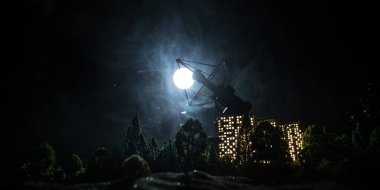 Uydu anteni siluetleri ya da gece gökyüzüne karşı radyo antenleri. Uzay gözlemevi ya da hava savunma radarı dramatik gece gökyüzünde. Yaratıcı sanat dekorasyonu. Seçici odak