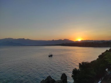 Gölde güzel bir gün batımı ve doğada bir tekne.