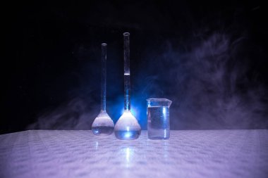 Eczane ve kimya teması. Araştırma laboratuarında çözeltisi olan cam deney şişesi. Bilim ve tıbbi geçmiş. Koyu renk arkaplan üzerinde laboratuvar test tüpleri, bilimsel araştırma ekipmanları konsepti