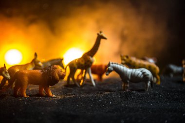 Bir grup hayvan sisli bir gecede yanan renkli bir geçmişle bir araya gelir. Hayvanlar hayatlarını ateşten kurtarmak için kaçıyorlar. Seçici odak.