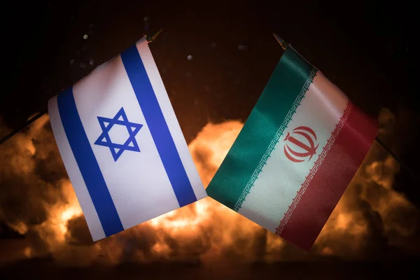 以色列和伊朗的小国旗在燃烧的黑暗背景上 战争危机和国家间政治冲突的概念 有选择的重点 — 图库照片