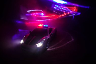 Polis arabası sisli bir arabayı gece takip ediyor. 911 acil durum arabası suç mahalline doğru hızla gidiyor. Yaratıcı dekorasyon. Seçici odak