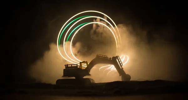 街の通りに建設現場 建設現場の夜の間に駐車された黄色の掘削機 暗い霧を基調とした背景に産業コンセプトテーブルの装飾 選択的焦点 — ストック写真