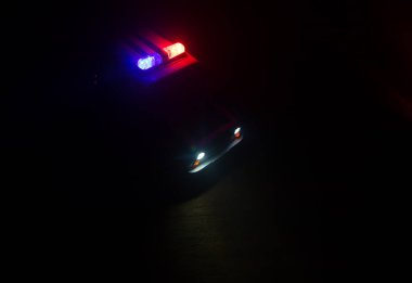 Polis arabası sisli bir arabayı gece takip ediyor. 911 acil durum arabası suç mahalline doğru hızla gidiyor. Yaratıcı dekorasyon. Seçici odak