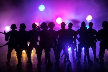 Çevik kuvvet polisi hazır olmak için işaret verdi. Hükümetin güç kavramı. Özel harekat polisi iş başında. Karanlık arka planda ışıklarla tüttürmek. Mavi kırmızı yanıp sönen sirenler. Seçici odak