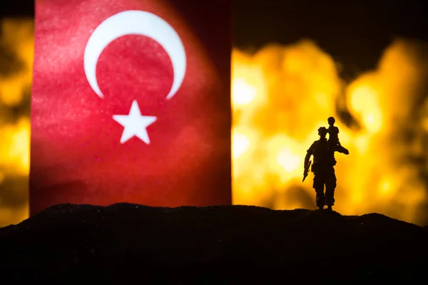 暗い背景を燃焼トルコの小さな旗 戦争の危機と国家間の政治的紛争の概念 トルコの旗に対する武装した兵士のシルエット 選択的焦点 — ストック写真