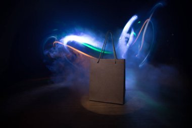 Alışveriş konsepti. Koyu renk masaüstüne saplı kahverengi alışveriş çantası. Seçici odak