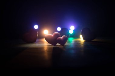 Sevgililer Günü geçmişi. Koyu tahta bir masada sevgililer günü kalbi. Yanan kalpler. Yüreğim yanıyor. Koyu tonlu sisli bir arka plan. Seçici odak