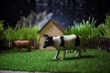 Çiftlikteki inek sürüsü. Çiftlik (köy) yaşam konsepti. Geceleri dekoratif oyuncak figürleri. Seçici odak