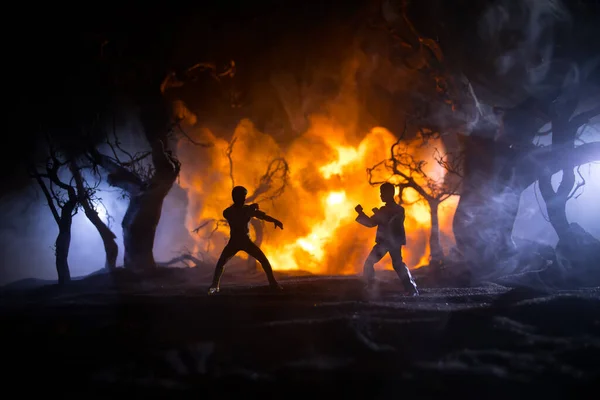 燃える森の中で空手選手の夜の戦闘シーン キャラクター空手 フィギュアアートワークの装飾をポーズ スポーツの概念 光で霧の背景を飾る 選択的焦点 — ストック写真