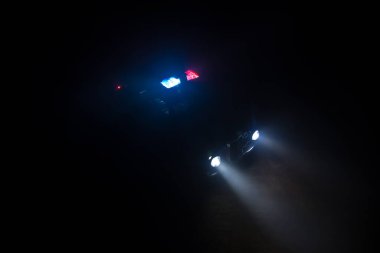 Polis arabası sisli bir arabayı gece takip ediyor. 911 acil durum arabası suç mahalline doğru hızla gidiyor. Yaratıcı dekorasyon. Seçici odak
