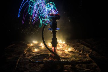 Shisha Konsepti. Siyah arkaplanlı shisha kasesinde sıcak nargile kömürü. Renkli ışıkları olan şık bir doğulu shisha. Seçici odak