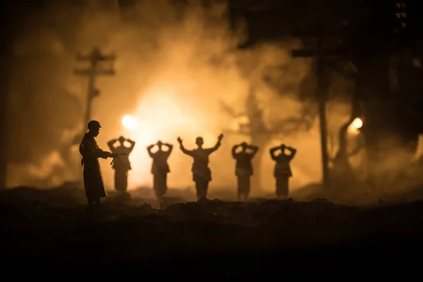 在战争的雾天背景下 军事轮廓描绘了战斗场景 一名德国士兵举起武器投降 带着枪的塑料玩具士兵俘虏了敌方士兵 有选择的重点 — 图库照片