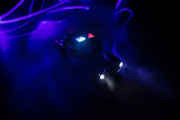 Police car chasing a car at night with fog background. 911 Emergency response police car speeding to scene of crime. Creative decoration. Selective focus